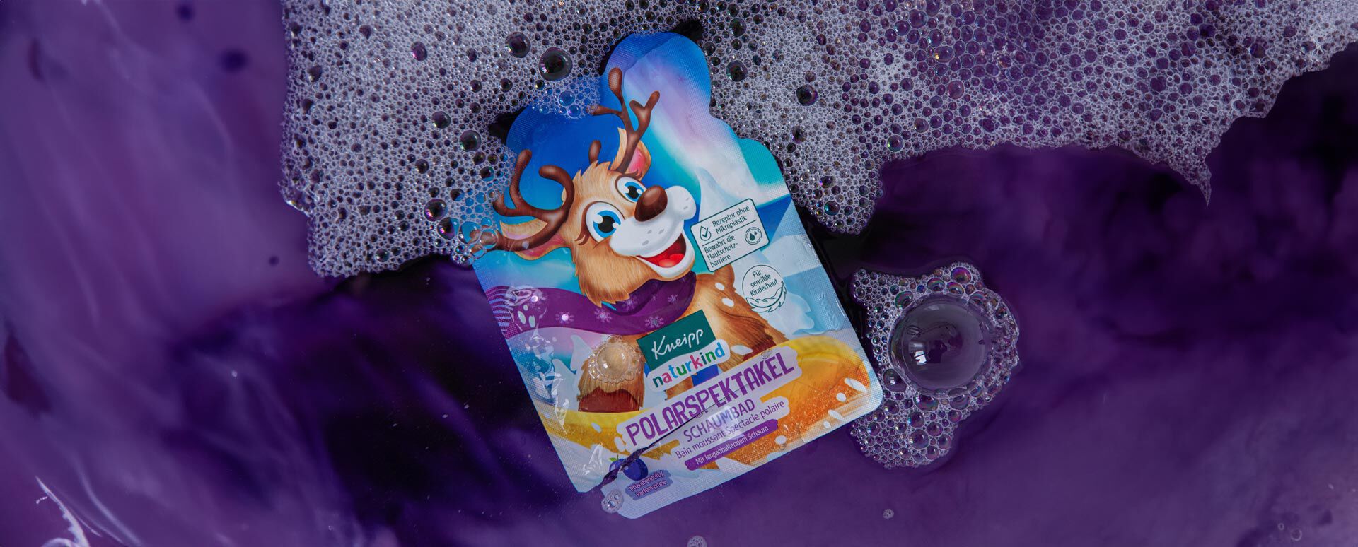 Kneipp Naturkind Schaumbad Polarspektakel schwimmt im lilafarbenen Badewasser